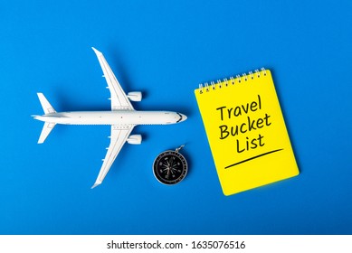 Travel Bucket List On Blue Background With Compas And Toy Airplane. Trip Travel Destination And Most Visited Places