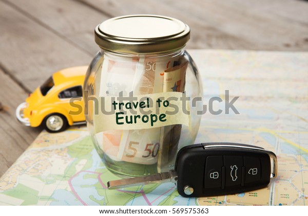 Travel\
by car to Europe - money jar, car key and\
roadmap