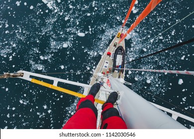 Travel By Sailing Boat In Antarctica, Extreme Dangerous Selfie, Person Feet Standing On Mast Of A Yacht With Floating Ice, Scary Top View, Adventure Photographer