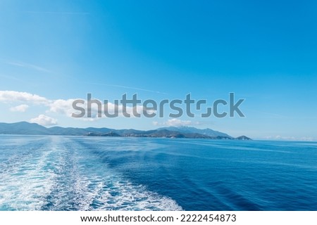 Travel by sea on a ship with a beautiful view of the island of Elba and the blue sky