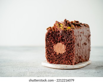 Travel Cake or Tube Cake or Voyage Cake filled center tube ganache and topped chocolate icing and pistachio. Chocolate loaf cake with chocolate cream-cheeese filled center. Copy space