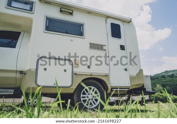Travel\
camp trailer car with on the ground with\
grass