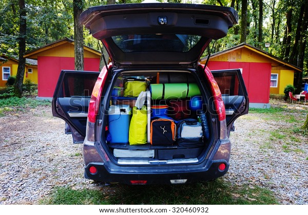 Travel car and camping luggage packed in the full car\
trunk. Outdoor wanderlust items. Outdoor, adventures and travel\
suv. Ready to go concept. Expedition, exploring swag and storage.  \
