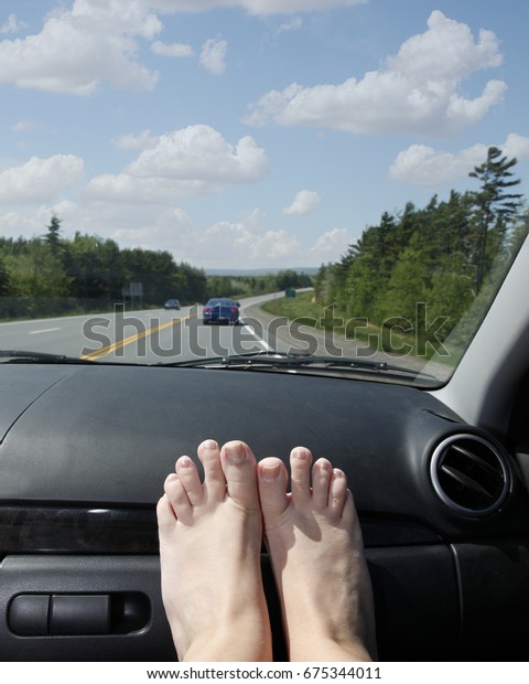 travel in the\
car on vacation, holiday, or road trip with feet on the dashboard\
and blue skies ahead in\
summer