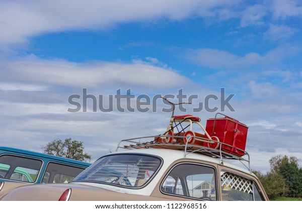 travel case on\
roof of oldtimer with tricycle at rural countryside south germany\
springtime near city\
stuttgart
