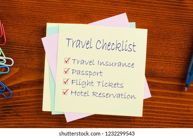 Travel Checklist Text On Note With Pen On The Wooden Table.