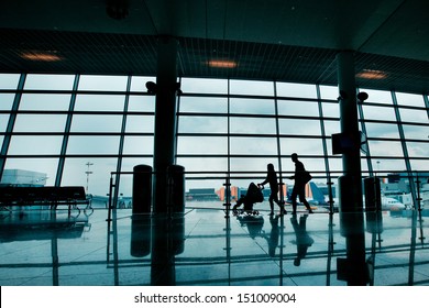 Travel With Children, Silhouettes Of Family With Buggy At The Airport