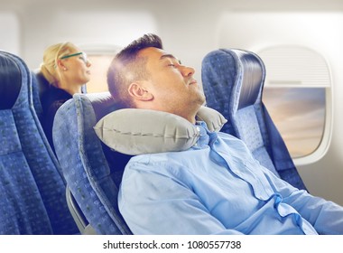 Travel, Comfort And People Concept - Man Sleeping In Plane With Inflatable Cervical Neck Pillow Over Porthole Background