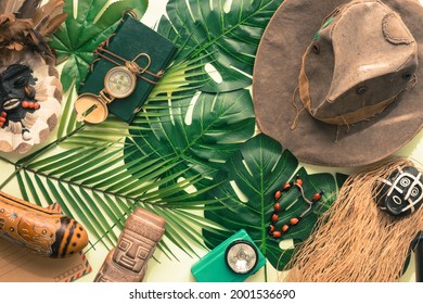 Travel concept around the world. Masks, compass, Indiana Jones style hat, Tropical leaves 
