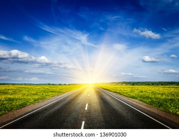 Travel Concept Background - Road In Blooming Spring Meadow On Sunset