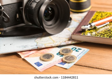 Travel concept. Camera, map, notebook, ball pen and money on wooden table