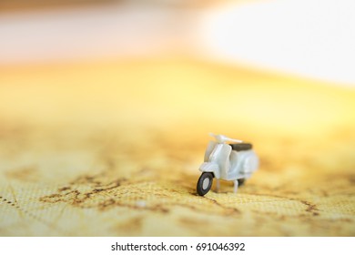 Travel Concept. Close up of mini motorcycle or scooter toy on map.