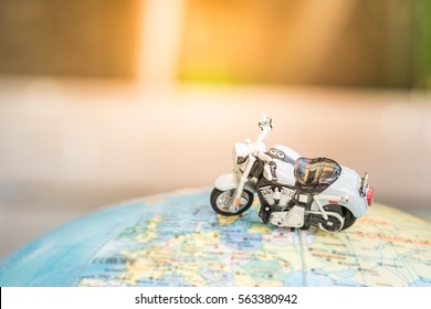 Travel Concept. Close up of motorcycle toy on world map balloon