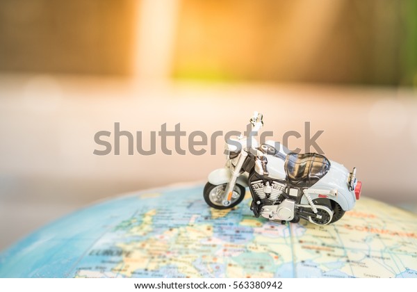 Travel Concept. Close up of motorcycle toy on\
world map balloon
