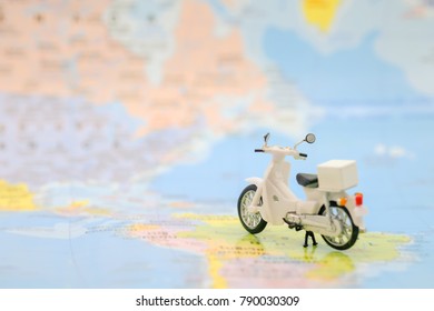 Travel Concept. Close up of vintage motorcycle toy on world map.
