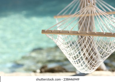 Travel concept with a hammock in a tropical beach with turquoise water in the background