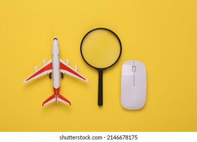 Travel concept. Passenger plane with pc mouse and magnifying glasses on yellow background. Top view. Flat lay.