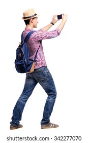 Travel Concept. Studio Portrait Of Handsome Young Man Taking Photo By His Phone Camera. Isolated On White.