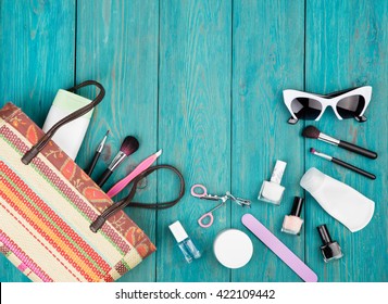 Travel Concept - Summer Women Set With Straw Bag, Sunglasses, Cosmetics Makeup And Essentials On Blue Wooden Background