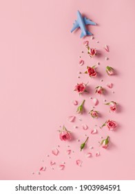 Travel Concept With White Blue Airplane, Rose Flowers And Petals On Pink Background. Minimal Love, Romance, Trip Or Vacation Concept. Top View, Flat Lay, Copy Space.