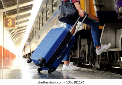 Travel concept,Women and the blue suitcase are going up the train ladder.