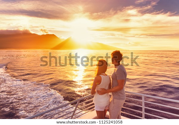 Travel cruise ship couple on sunset cruise in\
Hawaii holiday. Two tourists lovers on honeymoon travel enjoying\
summer vacation.