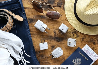 Travel essentials flat lay including power converter, voltage travel adapter 220v 110v Packing converters adapters for trips vacation in Europe UK Australia or North America - World traveler selection