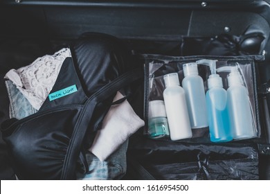 travel essentials for a holiday, luggage with few items inside and Packing Light label on them - Powered by Shutterstock