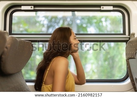 Travel and exploration of tourist woman by Sri Lankan train in first class wagon to famous places of the country. Romantic young traveler woman enjoying comfortable train ride, looking out to the