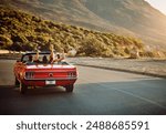 Travel, freedom and friends in car for road trip by sunset for countryside vacation or holiday. Adventure, nature and group of people in convertible for driving to weekend destination in Ireland.