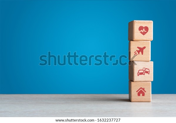 Travel health car and home personal insurance\
icons on wood blocks with blue backdrop - Conceptual insure and\
liability protection business model with copy space - Financial,\
legal and medical\
concept