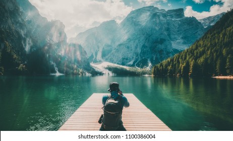 Travel hiker taking photo of Lake Braies (Lago di Braies) in Dolomites Mountains, Italy. Hiking travel and adventure. - Shutterstock ID 1100386004