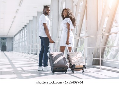 Travel And Honeymoon Concept. Young Black Couple With Suitcases Posing In Airport Before Departure, Turned At Camera And Smiling