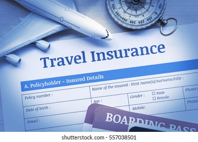 Travel Insurance Application Form On A Wood Table With A White Model Airplane, Boarding Pass And A Compass. Travel Insurance Is Intended To Cover Medical Expenses, Trip Cancellation, Lost Luggage, Etc