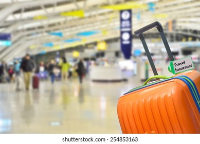 Travel Insurance. Blue suitcase with label at airport. - Powered by Shutterstock