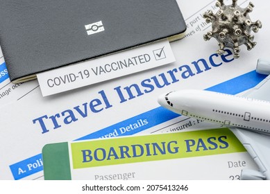 Travel insurance concept : Top view of travel insurance application form, a boarding pass, a passport, vaccine attestation, a plane. Travel insurance covers costs and losses associated with traveling