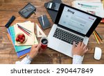 Travel itinerary concept.
Over shoulder view man writing managing trip diary sharing latest impressions vintage handcrafted natural wooden desk guidebooks pen pencil coffee mug