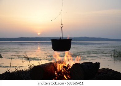 Travel a kettle over a fire burning on the river and sunset backgroun.
Cooking over a campfire - Powered by Shutterstock