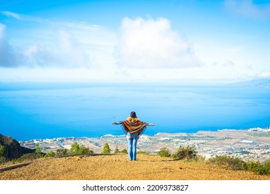 Travel lifestyle people copy space background image. One woman enjoy amazing trip destination opening arms agains a blue sky and ocean coastline view. Traveler person lifestyle. Tourist in nature
