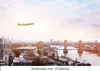 travel to London by flight, airplane in the sky over Tower Bridge - Powered by Shutterstock