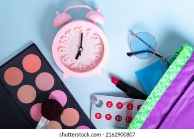 Travel Makeup Bag With Blush, Eye Shadow, Brush, Sunglasses, Lipstick, Pills And A Pink Alarm Clock As A Symbol Of Time. Hygienic Protection For Women On Critical Days. Travel Concept