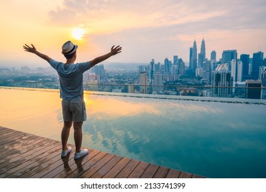 Travel man happy and raise hand up freedom enjoy view of beautiful landscape of Kuala Lumpur skyscraper in morning, Kuala Lumpur city, Malaysia. - Shutterstock ID 2133741399