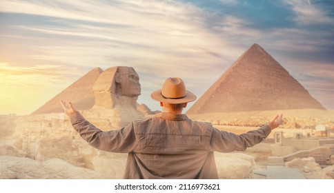 Travel man in hat background pyramid of Egyptian Giza and Sphinx, sunset Cairo, Egypt.