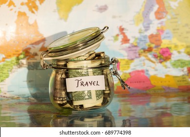 Travel money savings in a glass jar with map in background