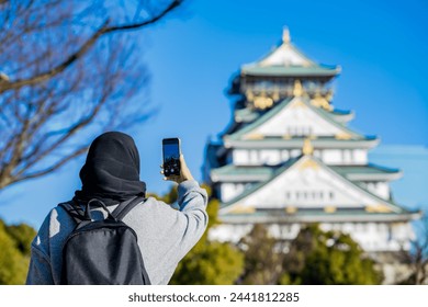 Travel, Muslim travel, Asian Muslim female tourist walking and visitor learning about history at Osaka Castle, Osaka Castle is one of the most famous landmarks in Japan and Osaka, holiday lifestyle. - Powered by Shutterstock