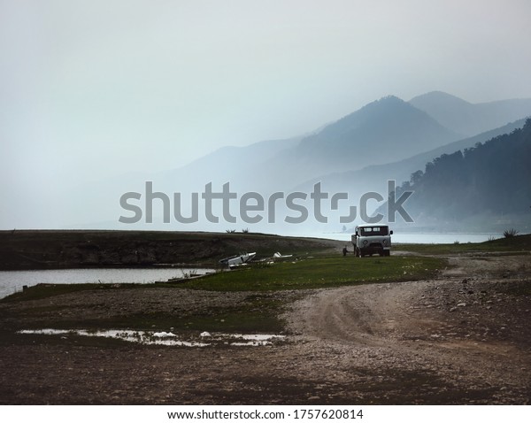 Travel on Lake Baikal by car during morning fog\
amid mountains