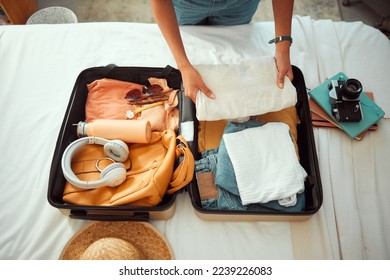 Travel packing, above and hands of a woman with clothes, holiday luggage and prepare for international summer. Suitcase, ready and person traveling with a suitcase, vacation clothing and hotel bag - Powered by Shutterstock