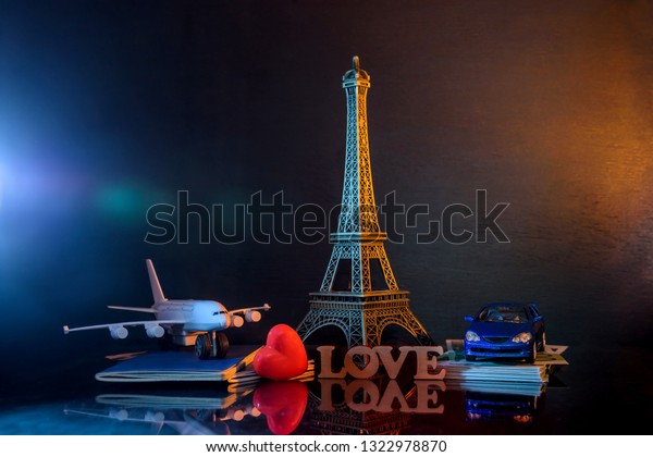 Travel to Paris\
with toy car and plane on\
dark