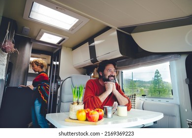 Travel People And Off Grid Lifestyle Living Van Life Inside A Camper. Happy Serene Couple Enjoy Van Life With Modern Rv Vehicle. Nature Outdoors Outside The Window View. Man And Woman Indoor