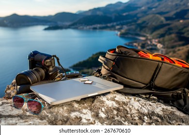 Travel photographer equipment on rocky mountain with beautiful landscape on the background
